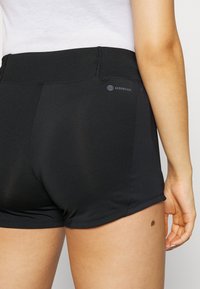 Bermudas deportivas negras hechas de una tela suave y ligera. Cuenta con una cintura alta y un sutil detalle de logo en la parte posterior.