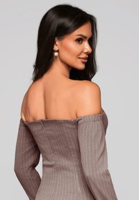 Robe à épaules dénudées, rayée marron avec des manches longues, en tissu texturé et à silhouette ajustée. Les détails notables incluent un décolleté lisse.