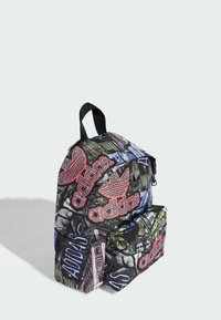 Zaino nero con loghi Adidas in stile graffiti colorati. Dotato di un compartimento principale e di una tasca frontale, entrambe con zip, con texture in tessuto.