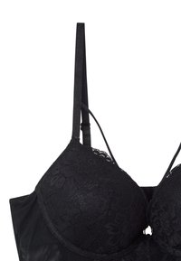 Czarny koronkowy biustonosz z gładką tkaniną pod spodem, z regulowanymi cienkimi ramiączkami i wzorzystą koronką na miseczkach.