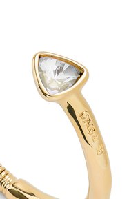 Anillo de oro con una piedra triangular clara. La banda es lisa, con sutiles estrías, y tiene grabado "UNO" en el lateral.