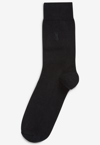 Schwarze Baumwollsocke mit geripptem Bund, ausgestattet mit einem dezenten, geprägten Ananas-Logo an der Seite. Glatte Textur und klassisches Design.