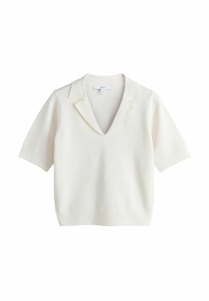 Femme aux longs cheveux châtain clair porte un haut blanc, un collier en or, une boucle d’oreille en or avec une pierre foncée et un maquillage naturel subtil.