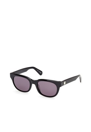Gafas de sol negras rectangulares con lentes tintados oscuros descansando sobre una superficie blanca, mostrando un leve reflejo en las lentes.