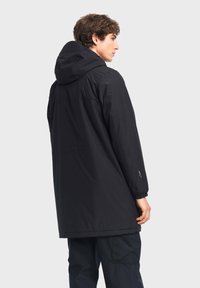 Parka nera, impermeabile, con cappuccio, chiusura con zip, maniche lunghe e polsini regolabili. Presenta una finitura liscia e opaca e una vestibilità relaxed.