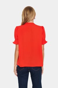 Blusa rossa a maniche corte con maniche a palloncino e dettagli arricciati, vestibilità comoda e tessuto leggero e liscio.