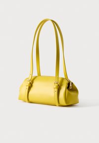 Κίτρινη δερμάτινη τσάντα χειρός με δύο λουριά ώμου, λεία υφή και στρογγυλεμένο σχήμα. Διαθέτει χρυσούς μεταλλικούς εξαρτήματα και κλείσιμο με φερμουάρ.