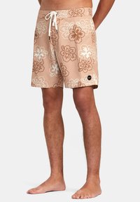 Beiga badshorts med vit och brun blommönster, elastiskt midjeband med dragsko, sidofickor och en liten logotyp på fållen.