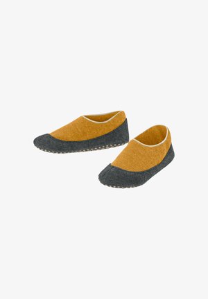 Pantofole di lana con tomaia senape e punta in feltro grigio, dotate di una superficie testurizzata e di una suola in gomma con piccoli punti per una buona aderenza.