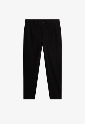 Svarta skräddarsydda byxor i ett mjukt tyg, med framfickor, dragkedja i gylfen och en diskret logotyp på midjebandet. Klassisk rak skärning.
