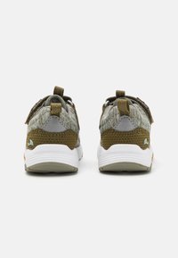 Et par barne sneakers i beige og olivengrønn med hvite såler, vist fra baksiden på en hvit bakgrunn.