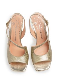 Guld- och beige slingbacksandaler med glänsande yta, öppen tå och utskärningsdesign. Har en spänneförslutning och subtil blommönstring.