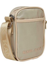 Borsa a tracolla in satin beige con un esterno testurizzato, chiusura con zip e logo embossato sul davanti, dotata di una tracolla intrecciata.