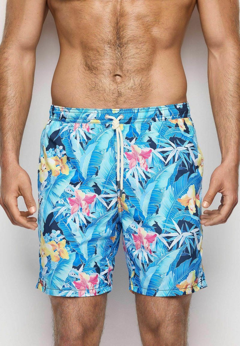 Los pantalones de baño florales azules presentan una mezcla de grandes flores rosas y amarillas con hojas verdes, una cinturilla con cordón y una tela suave y liviana.