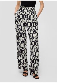 Pantalons à jambe large avec un motif abstrait noir et blanc. Fabriqués en tissu léger, comportant des poches latérales et une texture lisse.