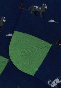 Calze di lana blu con tacco e punta verdi, decorate con un motivo di gatti giocosi in grigio, bianco e marrone su un tessuto testurizzato.