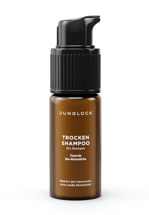 Brown bottle of Junglück dry shampoo with black pump dispenser, labeled with clay and organic corn starch for residue-free hair mattifying.
