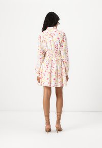 Φλοράλ φόρεμα με λευκή βάση, διαθέτει ροζ και κίτρινες λεπτομέρειες. Ελαστική μέση, μακριά φουσκωτά μανίκια και μήκος μέχρι το γόνατο.