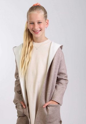 Beige sweater met een bruine, capuchon cardigan. De cardigan heeft een zachte textuur, zakken en een contrasterende binnenkant.
