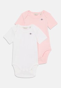 Zwei Kurzarm-Bodysuits: einer weiß und einer hellrosa. Aus weicher Baumwolle gefertigt, mit Druckknöpfen im Schritt und einem kleinen Logo.