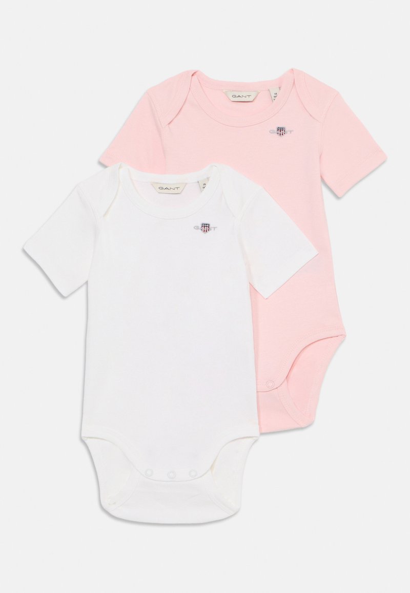 Zwei Kurzarm-Bodysuits: einer weiß und einer hellrosa. Aus weicher Baumwolle gefertigt, mit Druckknöpfen im Schritt und einem kleinen Logo.