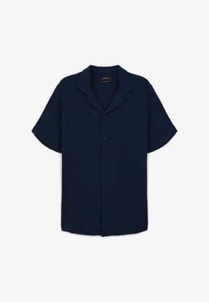 Chemise à manches courtes bleu marine avec col cranté. Fabriquée en tissu texturé avec une coupe décontractée et un éclat subtil, dotée de boutons à l'avant.