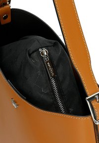 Borsa in pelle marrone con finitura liscia, dotata di una tasca con zip interna e di una tracolla staccabile con dettagli in metallo argentato.