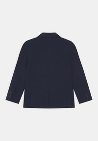 Námorně modrý blazer s klasickým límečkem, dlouhými rukávy, dvěma knoflíky na manžetách a jedním rozparkem na zadní straně. Hladká textilie.