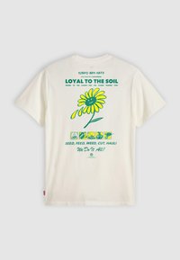 T-shirt en coton blanc avec un design graphique coloré d'une fleur souriante, du texte vert et divers icônes liés au jardinage au dos.