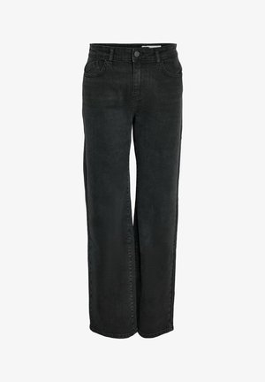 Femme portant un débardeur court blanc, un jean noir taille haute à jambes droites, et des baskets blanches avec des rayures noires.