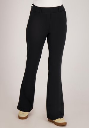 Zwarte wijde broek met een gladde stofafwerking, voorzien van een platte tailleband, zijzakken en een rechte pijp. Geaccentueerd met casual schoeisel.