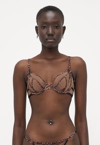 Sostén con un diseño de estampado de leopardo, fabricado con un material de malla transparente, soporte de aros y tirantes ajustables en negro.