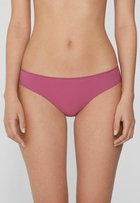 Bañador de bikini rosa con una textura suave y cobertura mínima. Presenta una cinturilla limpia y un diseño elegante sin patrones visibles ni herrajes.