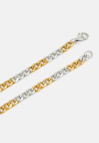 Bracelet en or et en argent composé de maillons alternés, avec une finition polie, un fermoir en homard et une boucle circulaire à une extrémité.