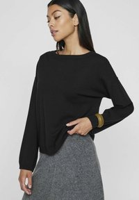Must musträäriga must pikad varrukad, lõdva lõikega, ribadega kaela- ja mansetid. Kombineeritud tekstuuriga halli seelikuga. Elegantne minimalistlik disain.