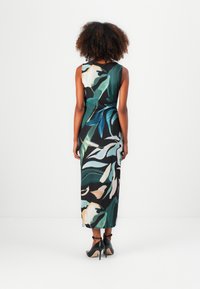 Maxikleid aus leichtem Stoff, mit einem floralen Muster in Grün, Weiß und Beige auf schwarzem Hintergrund. Ärmelloses Design und figurbetontes Schnitt.