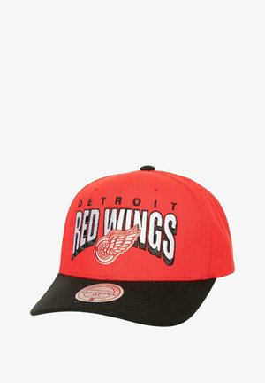 Red baseball cap with black brim, featuring embroidered "DETROIT RED WINGS" text and wing logo in white and red on the front.