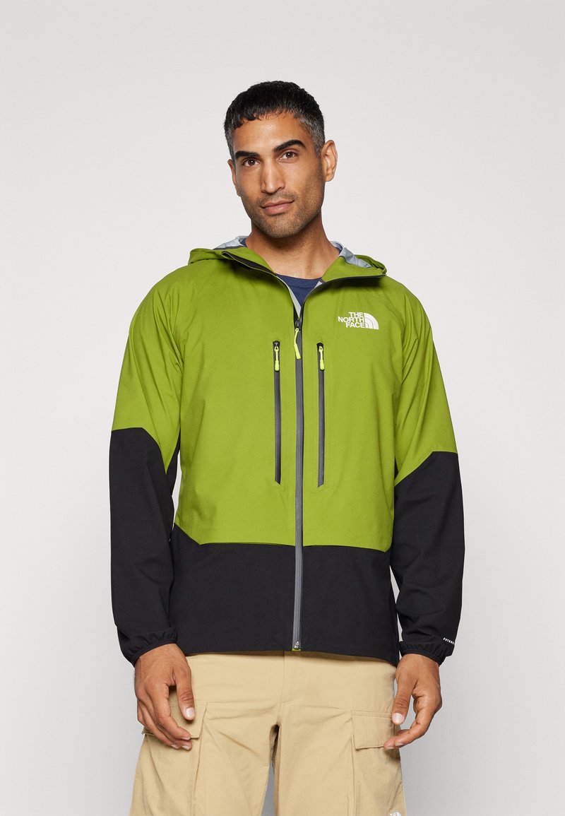 Kurtka typu windbreaker w jasnym zielonym i czarnym kolorze z zamkiem z przodu, kapturem i dwiema kieszeniami na zamek na piersi. Posiada elastyczne mankiety i logo.