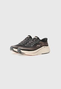 Baskets de sport noires avec une tige texturée, présentant des accents dorés métalliques, un design incurvé et une semelle intermédiaire rembourrée pour le confort.