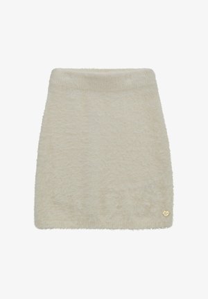 Mini jupe crème en fausse fourrure avec une texture douce, une ceinture côtelée, et un petit logo en forme de cœur doré sur l'ourlet.