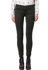 Jeans skinnies verde oscuro hechos de una mezcla de algodón, con una cintura de altura media, cinco bolsillos y un ajuste elegante, combinados con botas negras hasta el tobillo.