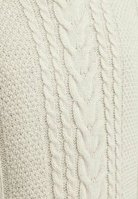 Jersey de punto trenzado en blanco roto, con un patrón de trenza gruesa y una textura tejida en todo su diseño. Tejido suave y cómodo.