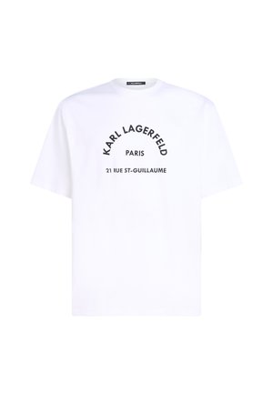 Valge puuvillane T-särk, millel on ümar kaelus ja lühikesed varrukad. Mustad tähed kirjutavad "Karl Lagerfeld Paris 21 Rue St-Guillaume" kumeras kujunduses.