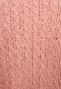 Pull en maille torsadée en laine douce et duveteuse de couleur rose clair, avec un motif de tresse tordue répétée et une texture côtelée.