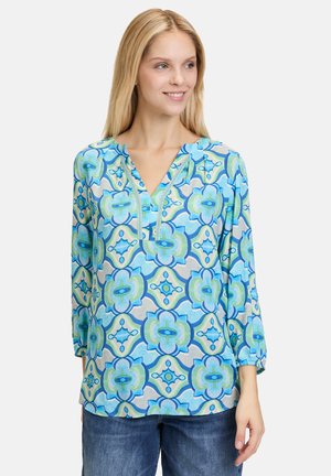 Blusa leggera con un vivace motivo floreale in tonalità di blu e verde, design a V e maniche a tre quarti.
