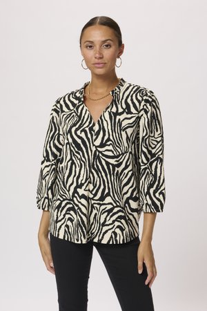 Blusa a rayas de cebra en blanco y negro con cuello y mangas de tres cuartos, que presenta una tela texturizada y un corte holgado.