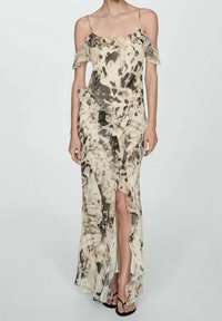 Robe longue avec un motif abstrait beige et marron, dotée de manches épaules dénudées, d'accents à volants et d'une fente haute. Tissu lisse et fluide.