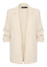 Béžový dámský blazer s nabranými tříčtvrtečními rukávy, klopovými límci a dvěma předními kapsami, označený "Soaked in Luxury" ve velikosti střední.