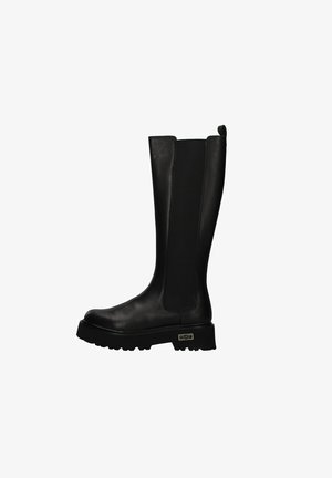 Zwarte kniehoge laarzen van glad leer met een platte, stevige zool en elastische zijkanten. Voorzien van een klein aantrekhaakje aan de bovenkant.