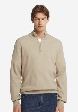 Beige Zip-Up-Pullover aus weichem Strickstoff mit geripptem Kragen und Bündchen. Ausgestattet mit einem Reißverschluss in Halb-Länge und lockerer Passform.